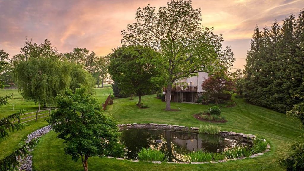 The Little Stone Cottage grounds and pond glowing under a golden sunset in Lancaster County, PA