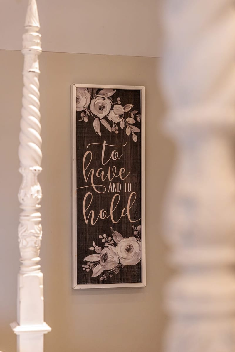 A framed sign reading 'to have and to hold' displayed inside the cottage