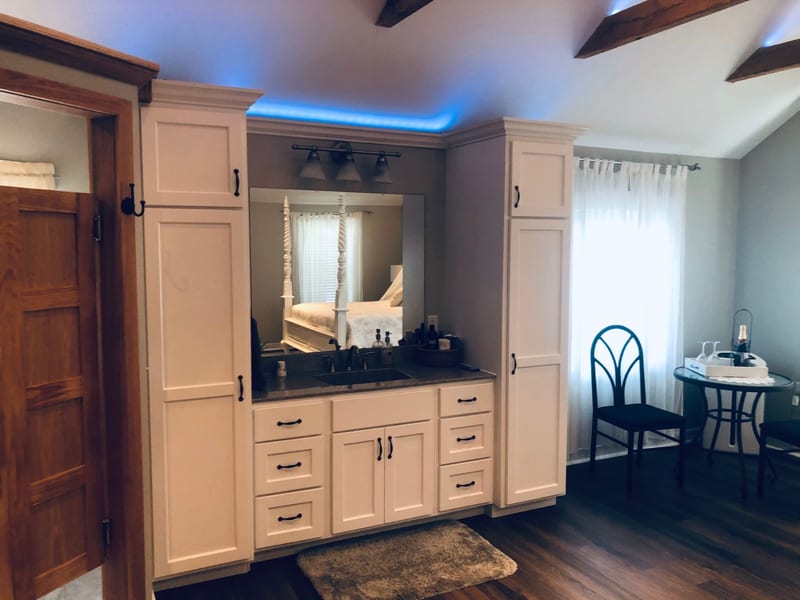 Master suite vanity with bistro table seating and soft ambient lighting